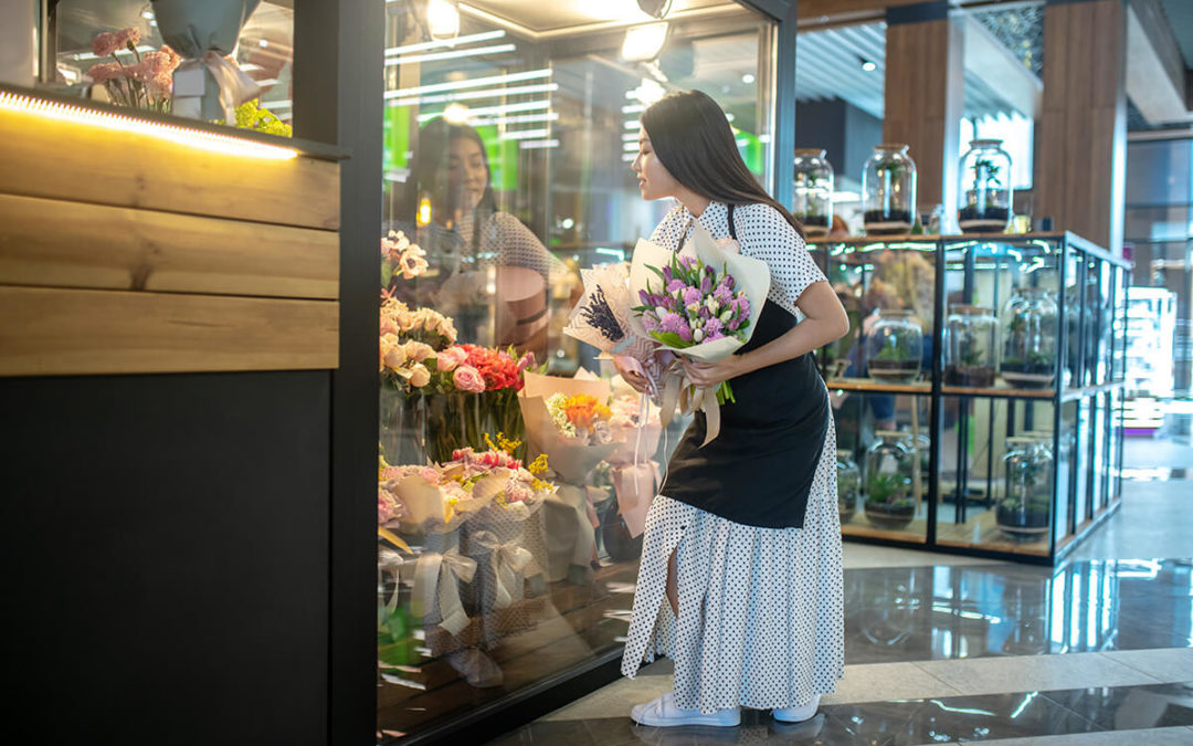 runette female in apron standing with bouquets